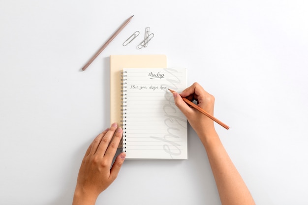 Ansicht einer Person, die mit Bleistift auf Papier schreibt