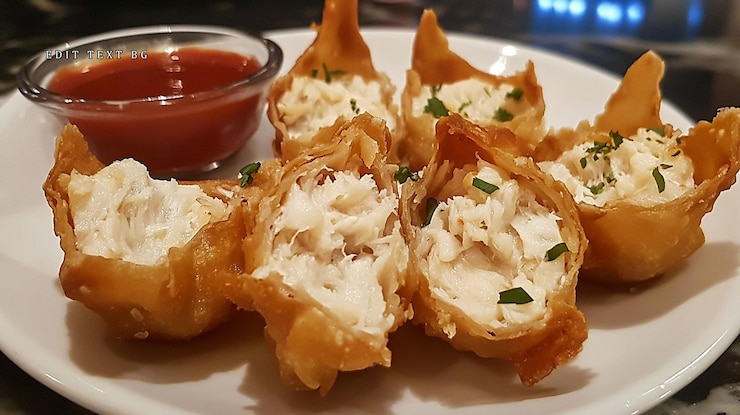 PSD aperitivi a base di granchio marrone dorato serviti con un lato di salsa di immersione rossa su un piatto bianco