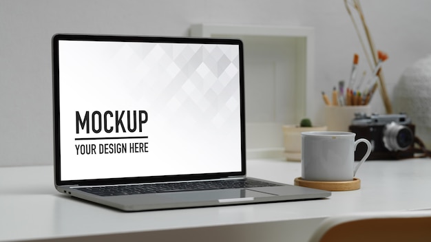 Arbeitsbereich mit digitalem Laptop-Modell, Kaffeetasse und Zubehör