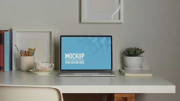 Area di lavoro con mockup di laptop, libri e articoli di cancelleria