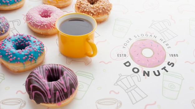 Arranjo de donuts coloridos e café preto com mock-up