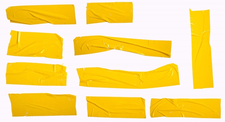 PSD assortment of crumpled yellow duct tape pieces on a white surface