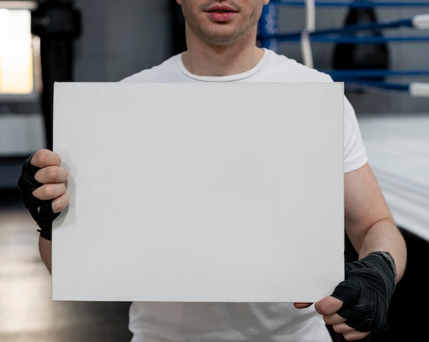 Atleta de boxeo sosteniendo una tarjeta de maqueta