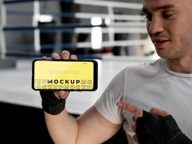 Atleta di boxe in possesso di un telefono mock-up