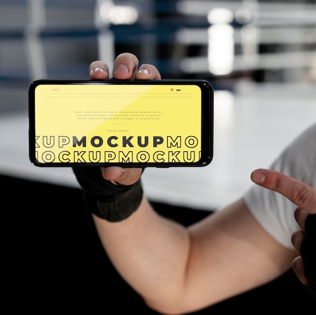 Atleta di boxe in possesso di un telefono mock-up