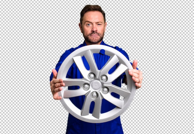 Automechaniker-Reparateur-Sporttrainerkonzept des mittleren Alters mit einem Fußball