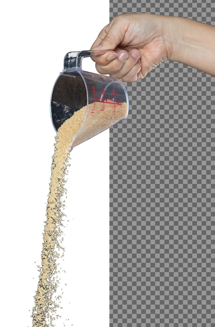 PSD azúcar marrón cae azúcar de grano marrón derramando nube abstracta vuela de la taza de medición hermosa semilla completa de caña de azúcar diseño de objeto de alimento enfoque selectivo congelado disparo fondo negro aislado
