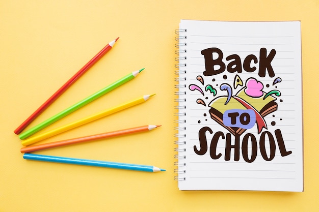 Back to school mockup con quaderno e quattro matite