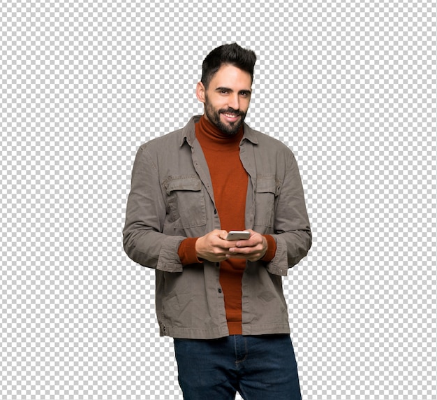 Bel homme à la barbe envoie un message avec le téléphone portable
