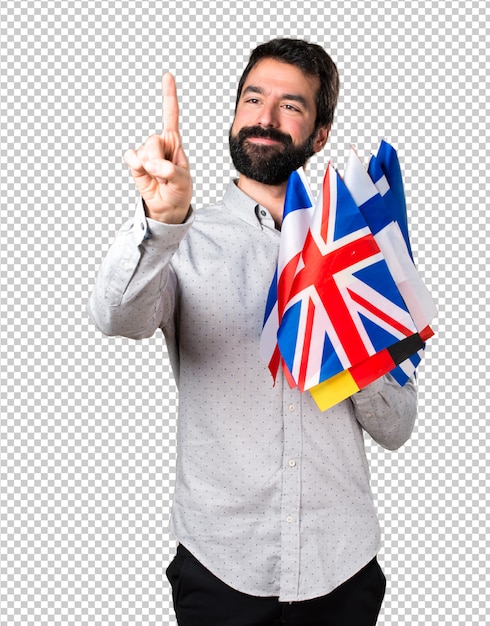 Bel homme à la barbe tenant beaucoup de drapeaux et touchant sur un écran transparent