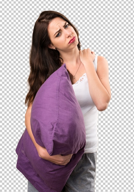 Bella ragazza con un cuscino con dolore alla spalla