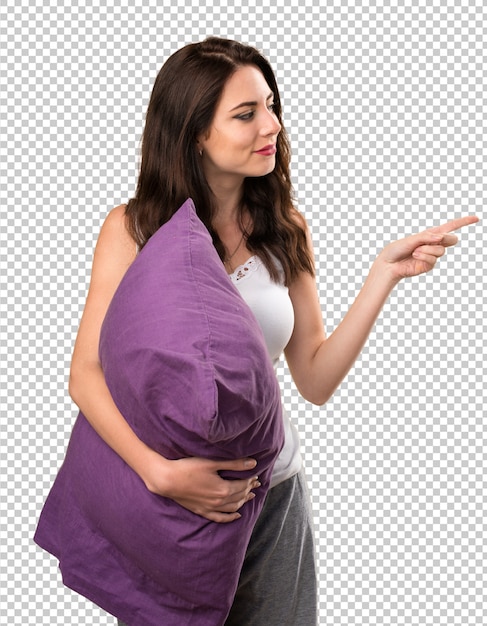 Belle jeune fille avec un oreiller pointant vers le latéral