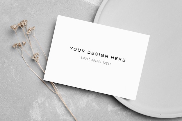 PSD blank invitation card mockup with dry flowers twig on grey