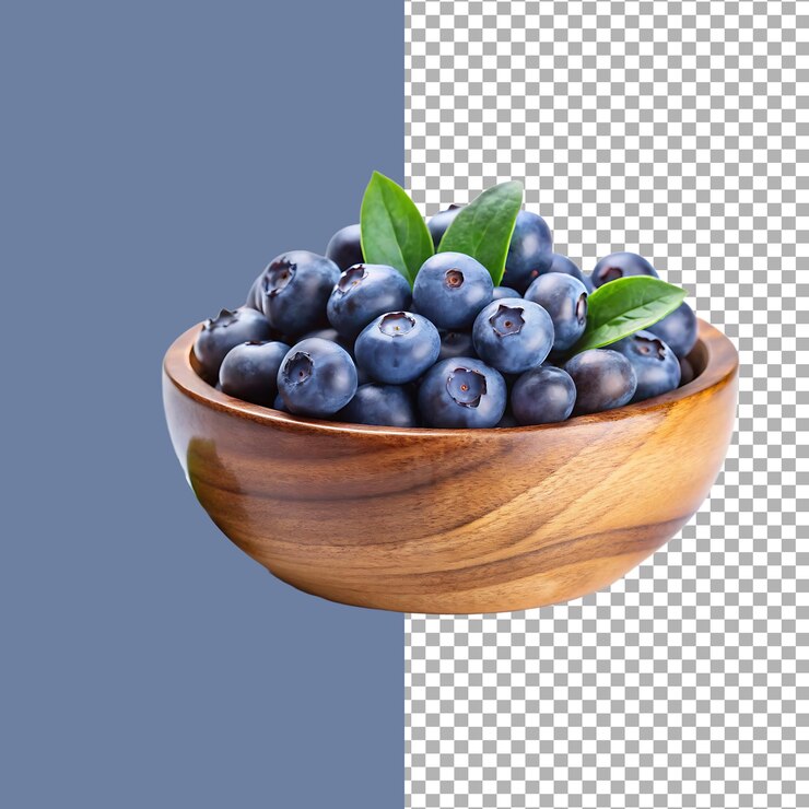 Blueberries frescos en un cuenco de madera con hojas verdes