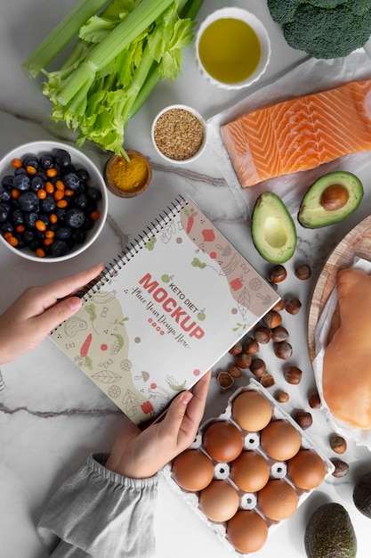 Bodegón de ingredientes de la dieta cetogénica con maqueta de cuaderno