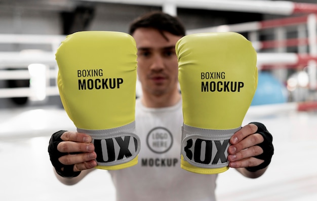 Boxsportler, der Modellhandschuhe hält, um zu trainieren