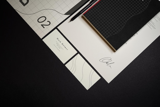 PSD briefpapier-branding-mockup-vorlage mit rotem a4-briefkopf, visitenkarte, umschlag, notizheft. echte fotografie mit dunklem hintergrund