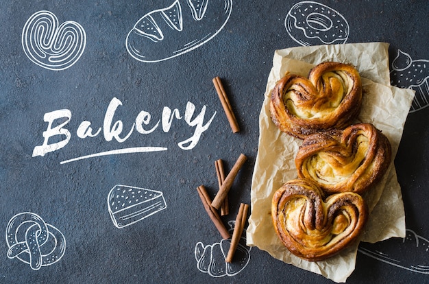 PSD brioches à la cannelle fraîche et parfumée. pâtisseries traditionnelles faites maison sur fond sombre.