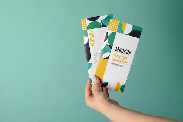 Broschüren-Mockup-Design in der Hand gehalten