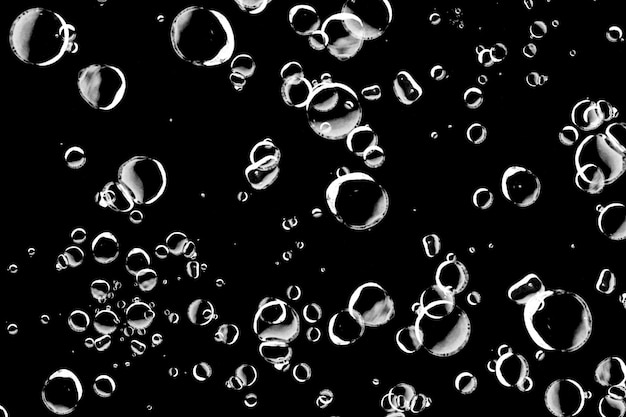 Burbujas transparentes flotando contra un fondo negro