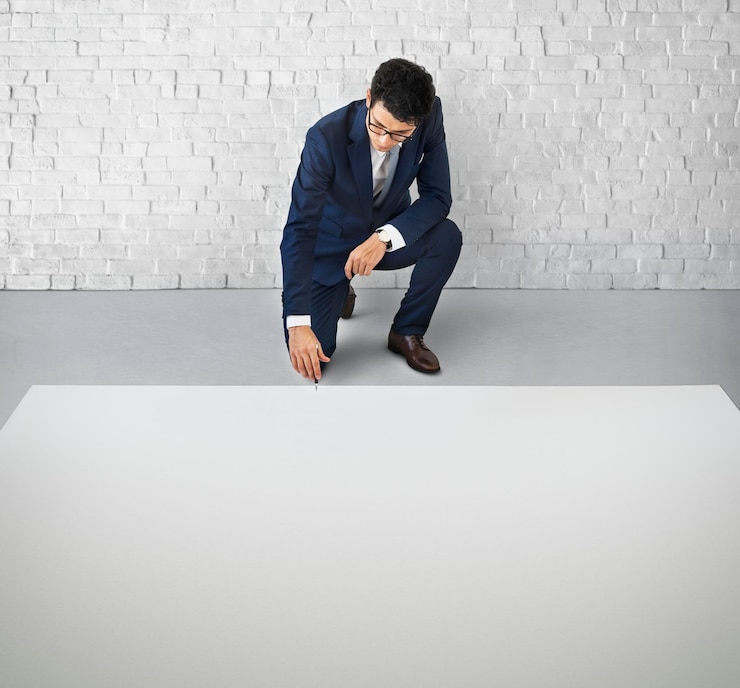 PSD businessman kneeling down on the floor with a big white copy space