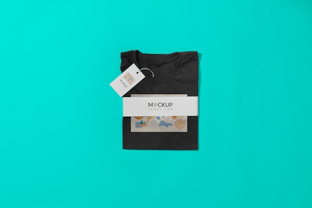 Camiseta negra doblada con maqueta de cinturón de papel.
