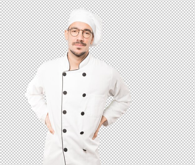 Cansado joven chef posando sobre fondo