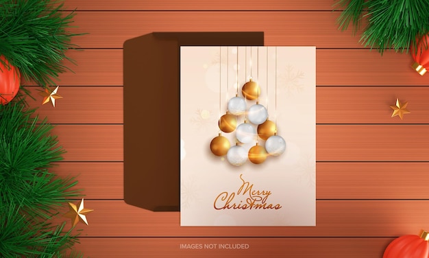 Carte de voeux joyeux Noël décorée de boules brillantes accrochées avec enveloppe sur fond de bois marron