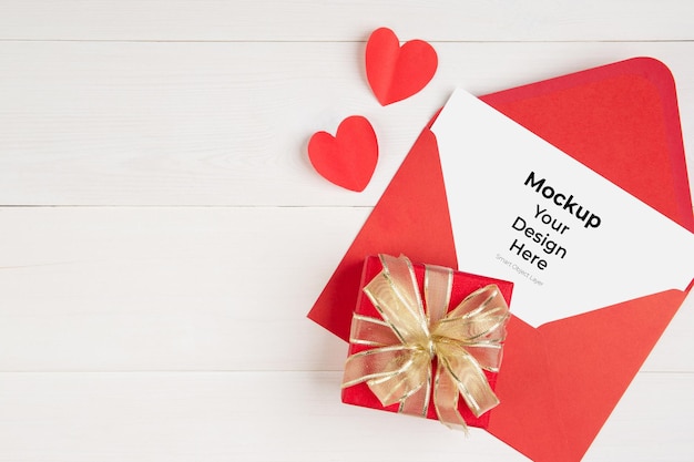 Cartolina in bianco e lettera e confezione regalo e forma di cuore sulla tavola di legno