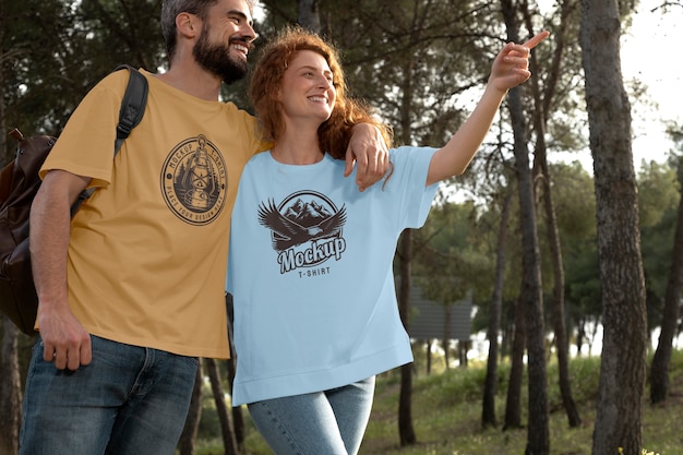 Casal ao ar livre na natureza usando maquete de camisetas