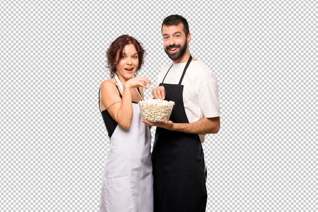 Casal de cozinheiros comendo pipoca