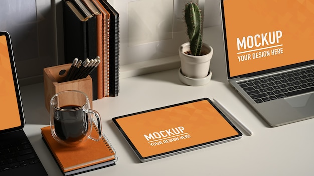 Cerca de maqueta de portátil y tablet con taza de café