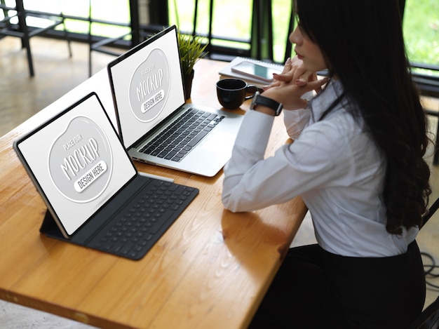 Cerca de trabajadora con maqueta de portátil y tableta