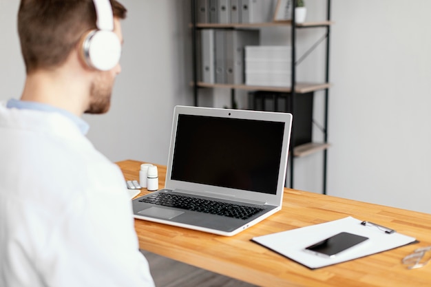 Cerrar doctor con laptop y auriculares