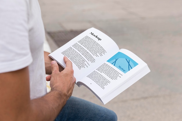 Cerrar hombre en el libro de lectura de la calle