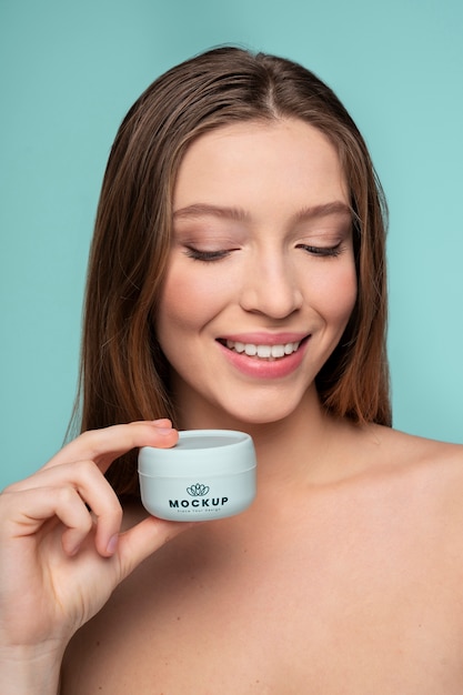 Cerrar mujer sonriente sosteniendo recipiente de crema
