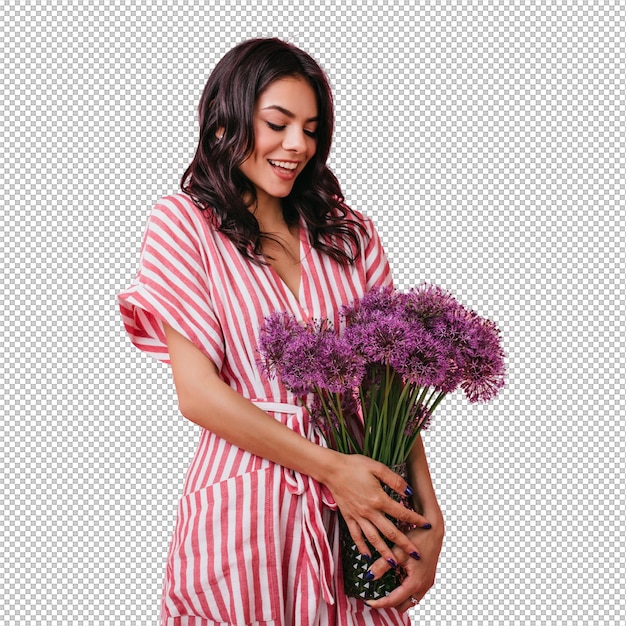 Une charmante femme latine regarde avec affection un bouquet de fleurs sauvages violettes une fille en robe rayée posant embarrassée