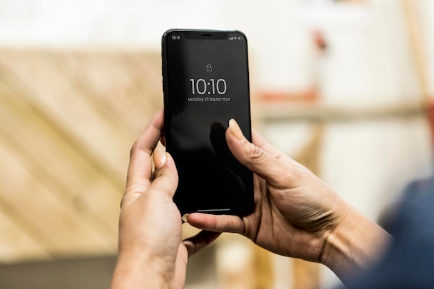 Charpentier féminin à l'aide de son téléphone dans un atelier