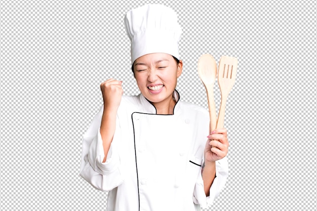 Chef de restaurante de mujer asiática bonita adulta joven con una herramienta de madera