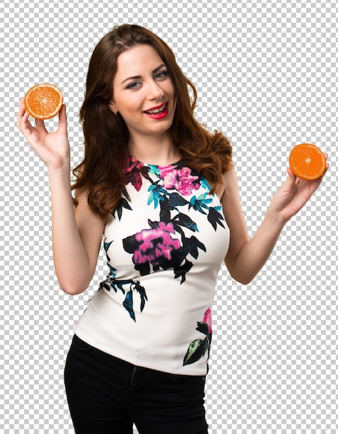 Chica joven hermosa que sostiene naranjas