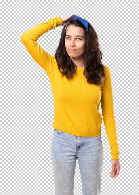 Chica joven con suéter amarillo y pañuelo azul en la cabeza con dudas