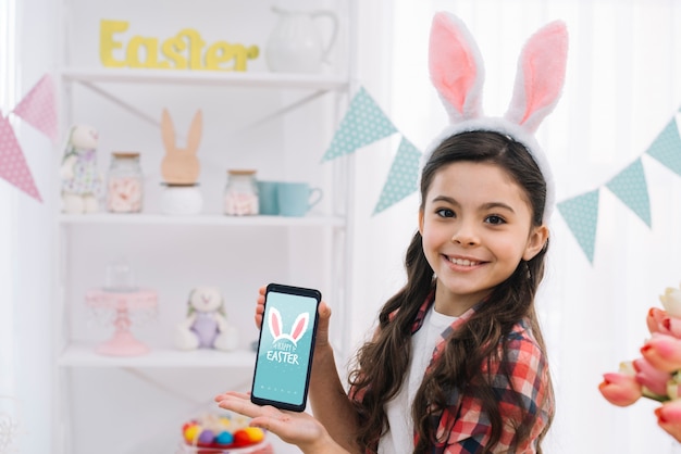 Chica con maqueta de smartphone en pascua