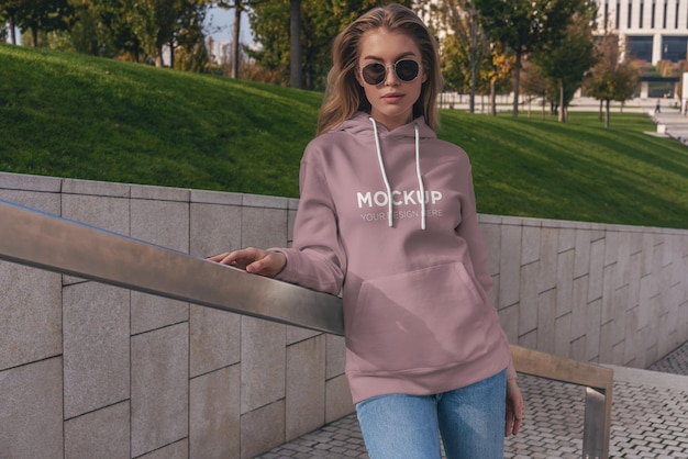 Chica de moda de maqueta de sudadera con capucha en la calle