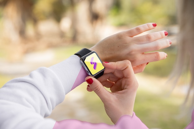 Chica de primer plano con capucha mirando smartwatch