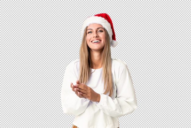 Chica rubia con sombrero de navidad aplaudiendo