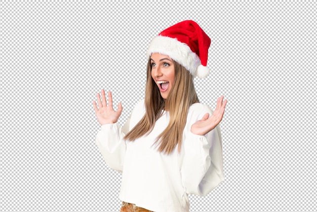 Chica rubia con sombrero de navidad con expresión facial sorpresa