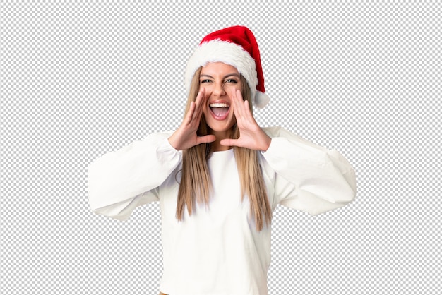 Chica rubia con sombrero de navidad gritando con la boca abierta