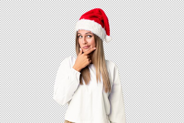 Chica rubia con sombrero de navidad pensando en una idea