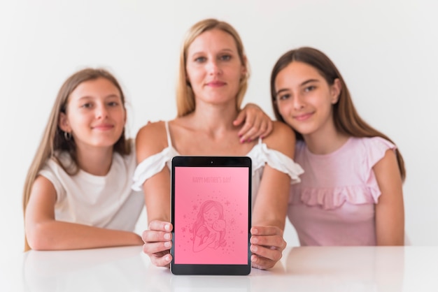 Chicas presentando maqueta de tableta para el día de la madre