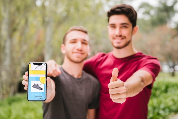 Chicos de tiro medio con teléfono mostrando aprobación